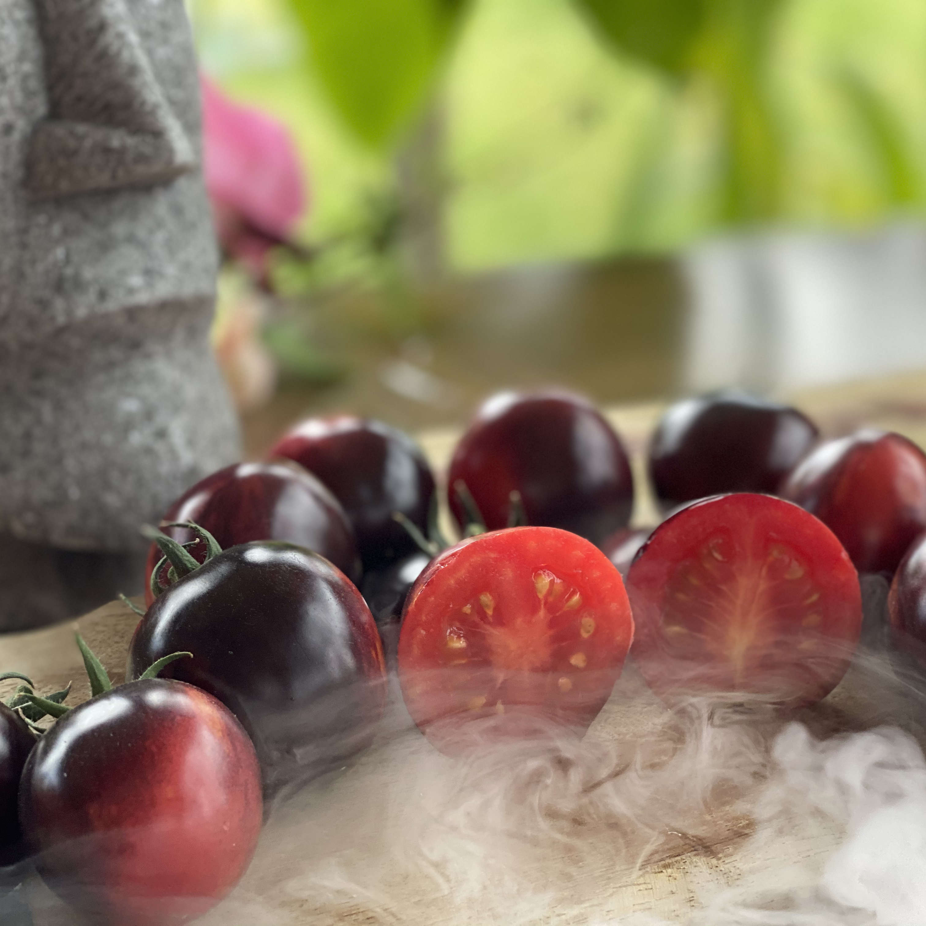 Mehrere kleine runde Tomatenfrüchte auf einem Brett