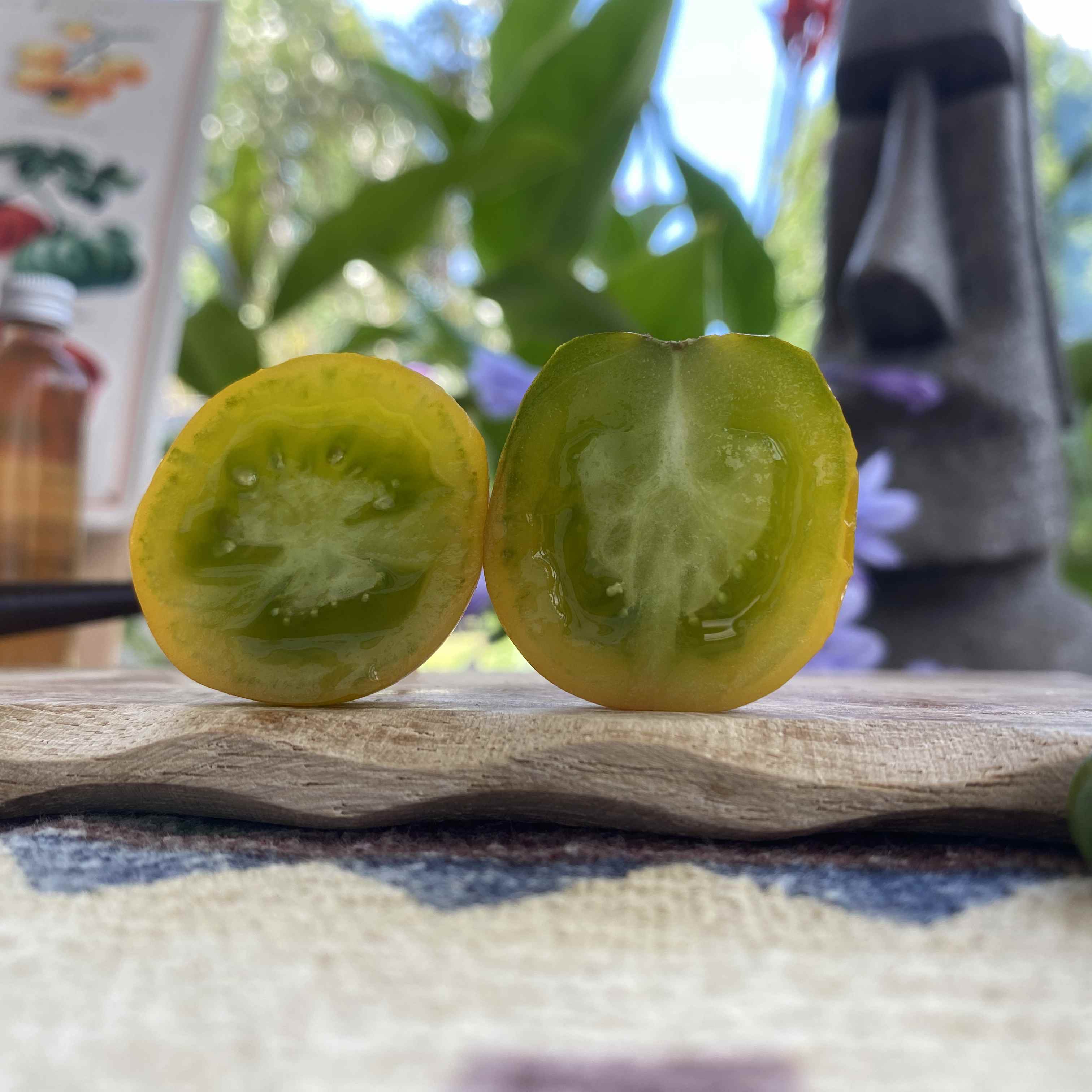 Eine halbierte grüne Tomatenfrucht auf einem Brett